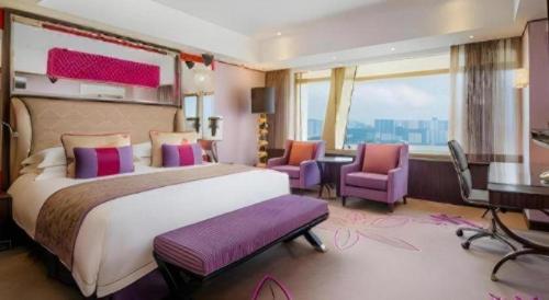 a hotel room with a large bed and a desk at Grand Lisboa Macau in Macau