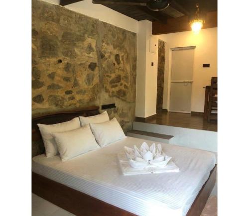 a bedroom with a bed with a flower on it at Kithulgala Cabana Resort in Kitulgala