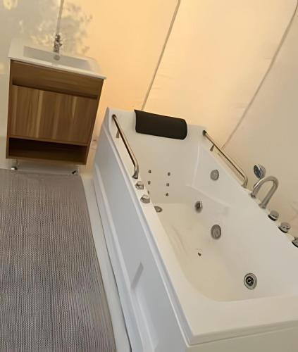 a white bath tub in a bathroom with a sink at Open Sky Bubble for sleeping under the stars in Valparaíso