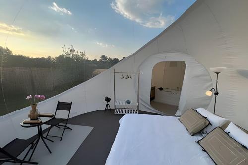 a white bedroom with a bed and a tent at Open Sky Bubble for sleeping under the stars in Valparaíso