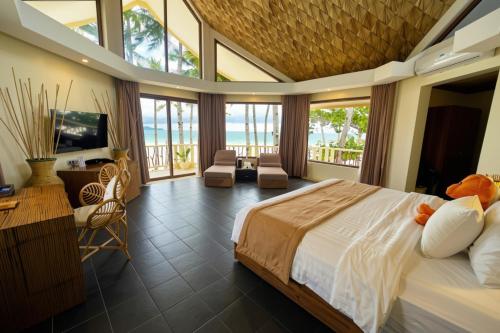 a bedroom with a large bed and a living room at Ambassador In Paradise in Boracay