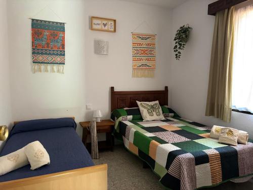 a bedroom with two beds and a table and a window at Villa Herrero in La Adrada