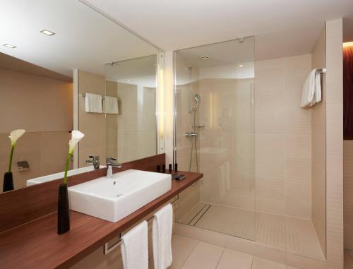 a bathroom with a sink and a shower at Meliá Düsseldorf in Düsseldorf