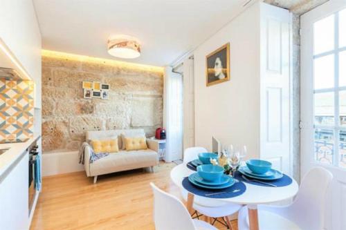 uma sala de estar com uma mesa branca e cadeiras em Sendme2Portugal: Loureiro no Porto