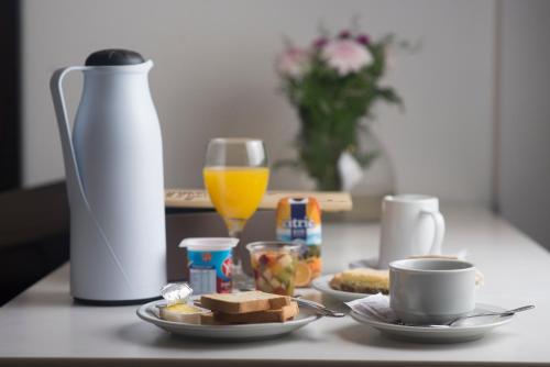 a table with a plate of breakfast food and a glass of orange juice at Awwa Suites & Spa in Buenos Aires