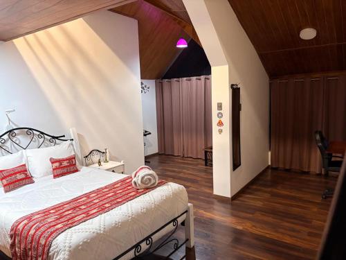 a bedroom with a bed with red pillows on it at Casa Munay in Huancayo