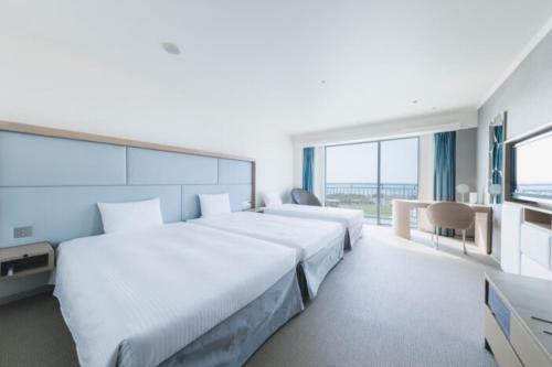 a hotel room with two beds and a television at Laguna Garden Hotel in Ginowan