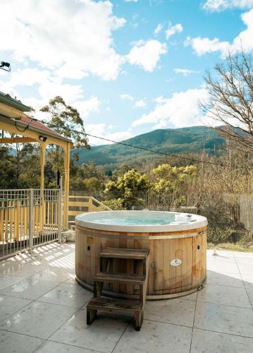 a hot tub on a patio with a view of a mountain at Warburton Stays Grand View in Warburton