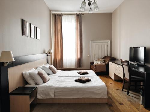 a hotel room with a bed and a television at Mini-Hotel Under The Roof in Lviv