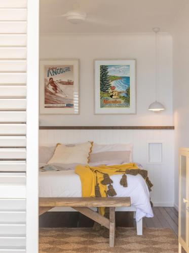 a bedroom with a bed and a wooden bench at Bay Properties Pacific Lodge in Yamba