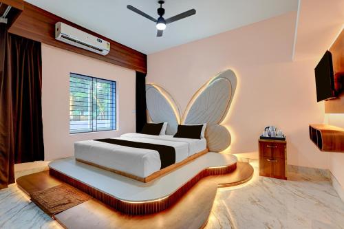 a bedroom with a bed with a butterfly shaped headboard at Hotel O Bhubaneswar New Station Road in Bhubaneshwar