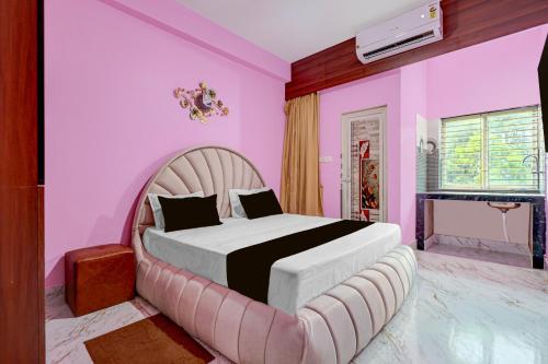 a bedroom with a large bed in a pink room at Hotel O Bhubaneswar New Station Road in Bhubaneshwar
