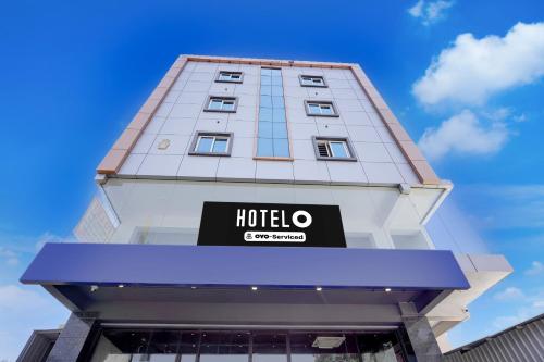a tall building with a hotel sign on it at Super Hotel O Phase 2 Christ Nagar Bangalore in Bangalore