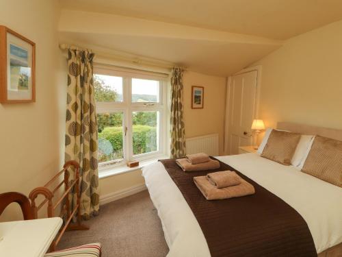 a bedroom with a large bed and a window at The Orchard in Kendal