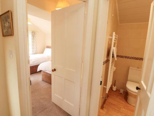 a bathroom with a toilet and a bed in a room at The Orchard in Kendal