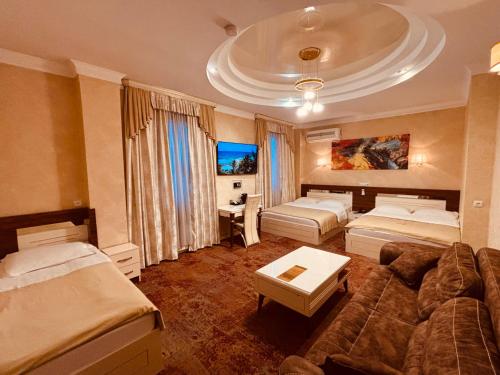 a hotel room with two beds and a couch at Hotel Agava in Tbilisi City