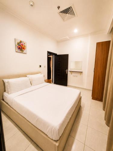 a bedroom with a large white bed in a room at Atlantis International Hotel Apartments in Kuwait