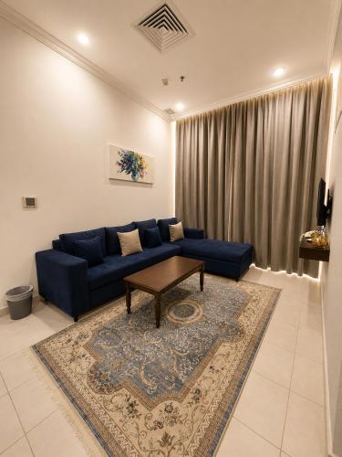 a living room with a blue couch and a table at Atlantis International Hotel Apartments in Kuwait
