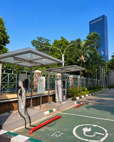 a parking lot with a bus stop with red hoses at Grand Tropic Suites Hotel in Jakarta
