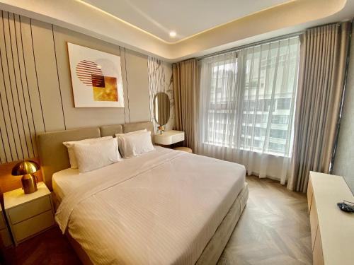 a bedroom with a large white bed and a window at Premium Midtown serviced apartment in Ho Chi Minh City