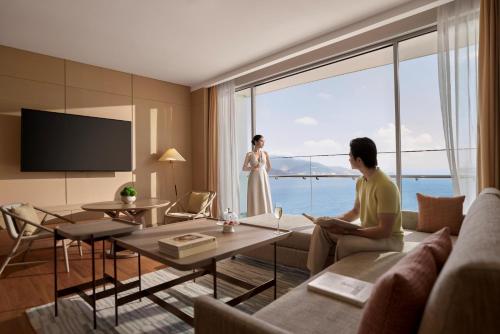 a man sitting on a couch in a living room with a woman at Hyatt Regency Nha Trang in Nha Trang