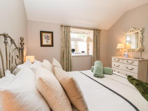 a bedroom with a white bed with white pillows at 1 Church Barns in Great Driffield