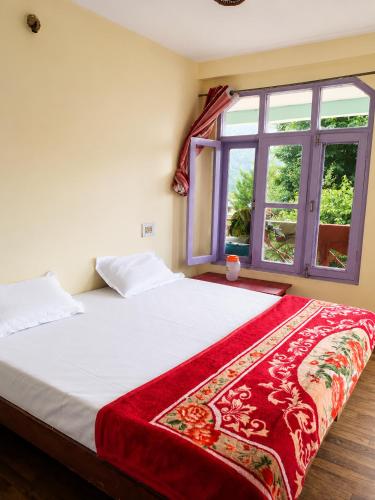 a bedroom with a large bed with a window at Jain Residency in Manāli