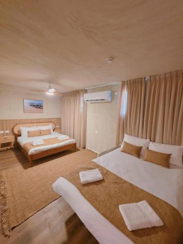 a large bedroom with two beds and a couch at Lumi Hotel Eilat - מלון בוטיק באילת in Eilat
