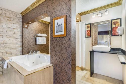 a bathroom with a tub and a sink at Days Inn by Wyndham Sylvan Lake in Sylvan Lake