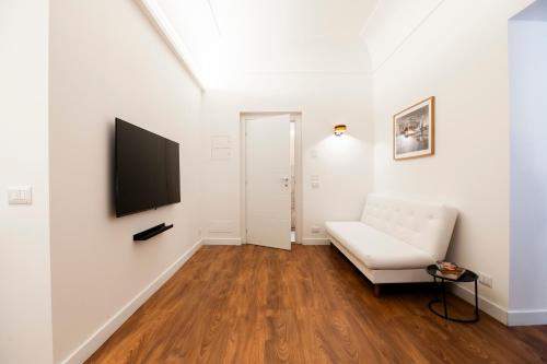 a living room with a white couch and a flat screen tv at Palazzo del Poeta - Dimora Contemporanea in Palermo