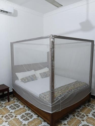a bed in a glass box in a room at Casa twende A in Nungwi