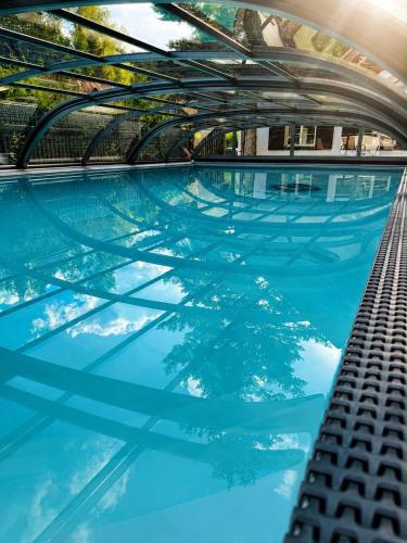 a swimming pool with blue water in a building at Chalupa Hnízdo Jetřichovice in Jetřichovice