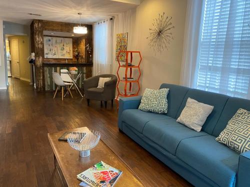 a living room with a blue couch and a table at Steps into the French Quarter in New Orleans
