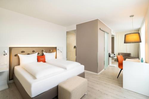 a hotel room with a bed and a chair at elaya hotel kleve, Trademark Collection by Wyndham in Kleve