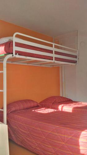 two bunk beds in a room with red sheets at Premiere Classe Grenoble Nord Moirans in Moirans