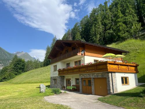 a house with a balcony on a mountain at Ferienhaus Alpenblick, ganzes Ferienhaus, 5 Zi, 4 Bäder, gratis Parkplatz, Sonnenterrasse in Heiligenblut