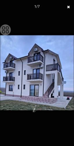 a large white building with stairs and balconies on it at Pensiunea LA ANI in Vadu