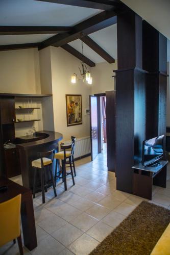 a kitchen with a bar and a dining room with a table at Nostos Hotel in Kato Loutraki