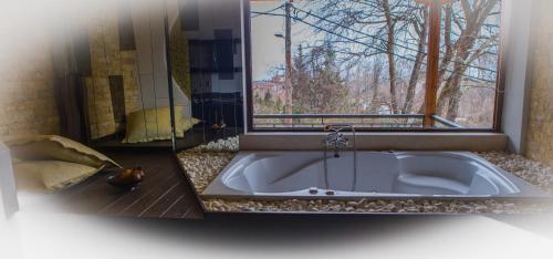 a bath tub in a bathroom with a window at Nostos Hotel in Kato Loutraki