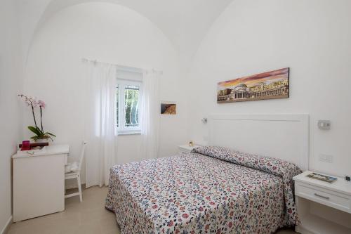 a white bedroom with a bed and a window at Villa Pollio Guest House in Anacapri