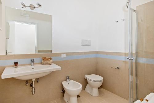 a bathroom with a sink and a toilet and a mirror at Villa Pollio Guest House in Anacapri