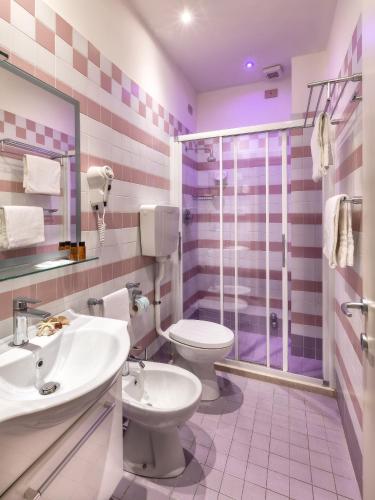 ein Badezimmer mit Toilette, Waschbecken und Dusche in der Unterkunft ACasaMia WelcHome Rimini Hotel By OasiGroup Hotels in Rimini