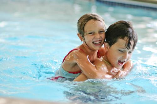 two young boys playing in a swimming pool at AmericInn by Wyndham St. Peter in Saint Peter
