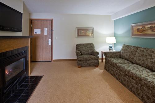 a living room with a couch and a fireplace at AmericInn by Wyndham St. Peter in Saint Peter