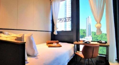 a bedroom with a bed and a chair and a window at Ehotel in Hong Kong
