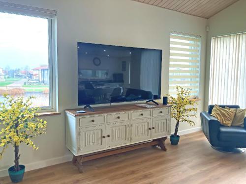 a living room with a large flat screen tv at Chestnut Cottage - Uk48294 in Great Yarmouth