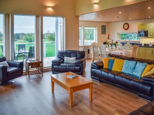 a living room with couches and a table and a kitchen at Chestnut Cottage - Uk48294 in Great Yarmouth