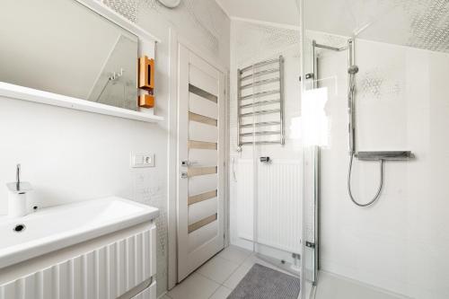 a white bathroom with a sink and a shower at Великі котеджі з терасами у моря Совіньйон in Odesa