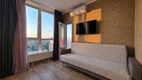 a living room with a couch and a flat screen tv at Apart with Panorama View Позняки Харьковская in Kyiv
