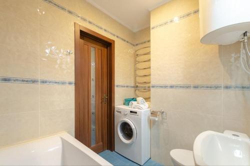 a bathroom with a washing machine and a sink at Apart with Panorama View Позняки Харьковская in Kyiv